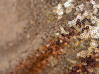 Abstract background for design or product. Background with glitter on golden sequin fabric. Lateral...