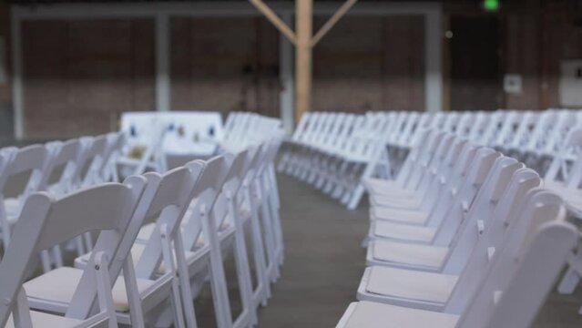rows of chairs at a wedding in a brick warehouse 