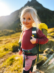 Child girl hiking with backpack family travel summer vacations outdoor, 4 years old kid climbing mountains active healthy lifestyle adventure trip - 783352336