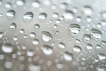 A close-up shot of shimmering water droplets on a glass surface, providing a unique and contemporary texture. 