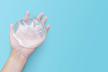 Top view silicone implant breast augmentation on space blue or turquoise background, Gel type and...