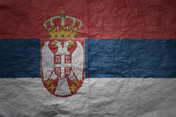 big national flag of serbia on a grunge old paper texture background