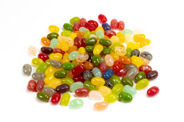 Assorted candy beans of various colors on a white background