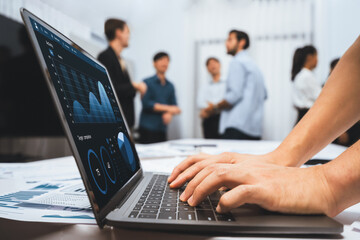 Analyst team uses BI Fintech on a laptop to analyze financial data on blurred background. Business people analyze BI dashboard for insights power into business marketing planning. Prudent - Powered by Adobe