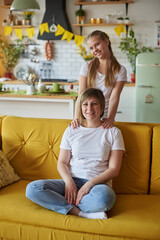 Mom and daughter on the couch on Mother's Day looking at the camera