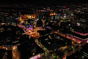 Fototapeta premium Night time aerial photo of the town centre of Leeds in West Yorkshire UK showing the bright lights of the city and traffic at Christmas time