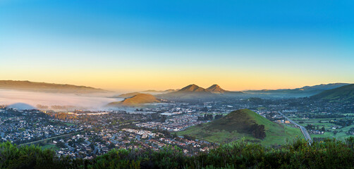 sunset from a view of city and mountains and clouds, fog