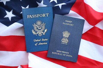 Naklejka premium Passport of India with US Passport on United States of America folded flag close up