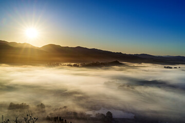 sunlight over valley, fog, clouds, from view over mountains