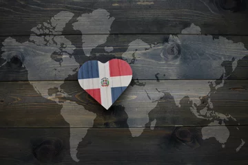 Foto op Canvas wooden heart with national flag of dominican republic near world map on the wooden background. © luzitanija