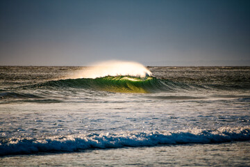 Backlit breaking wave with spray