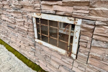 Abandoned warehouse window. Rusty grate window. Safety security protection. Light brick wall with...