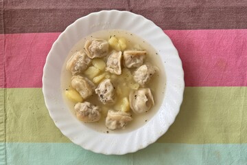 Delicious home dumplings from a white plate from a table in a restaurant. Close-up