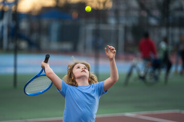 Kid playing tennis on court. Child hit tennis ball with tennis racket. Active exercise for kids....