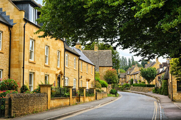 Tree line street of a beautiful Cotswolds village, Gloucestershire, England