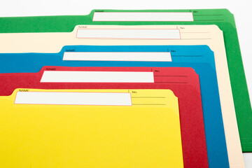colorful file folders with blank labels spread out isolated on white