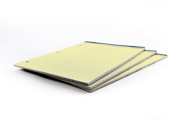 pads of yellow three hole punched legal note paper isolated on white