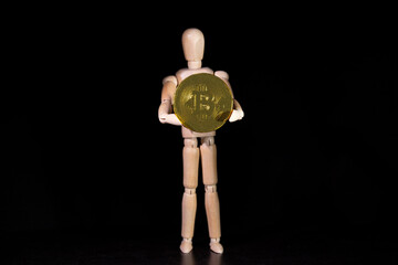 Kryptowaluta Bitcoin, postać trzymająca złotą monetę - obrazy, fototapety, plakaty