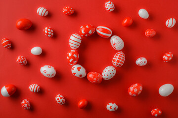 Easter backgrounds with a round frame of red and white Easter eggs on a bright red background. A...