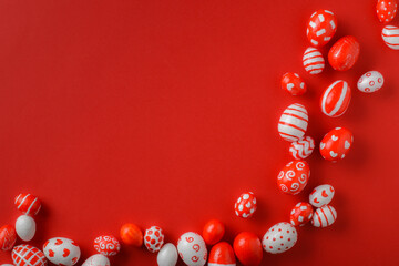 Easter backgrounds, scattered Easter red and white eggs on a bright red background. Copy space. Flat lay, top view
