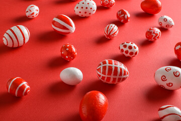 Easter backgrounds, scattered Easter red and white eggs on a bright red background. Copy space. Flat lay, top view