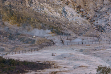 Landscape of Solfatara at Campi Flegrei near Naples at evening with smoke and steam coming out the...
