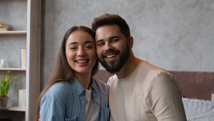 Happy couple in love portrait of Caucasian family married wife and husband newlyweds affectionate cuddling looking at camera tender lovely relationship smiling woman girlfriend and man boyfriend faces