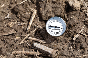 Soil thermometer in soil of farm field. Soil temperature, planting season and farming weather...