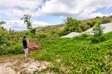Tortola, British Virgin Islands - March 27, 2024: A photographer taking landscape shots on Norman Island
