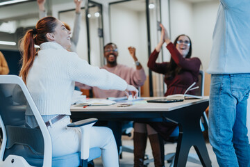 Obraz premium A diverse group of business people celebrating their successful finished project in an office. They are smiling and feeling overjoyed, showing teamwork and achievement.
