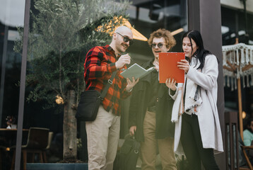 Three business partners engaged in a collaborative discussion with digital tablet and notebook during an outdoor meeting at a cafe.