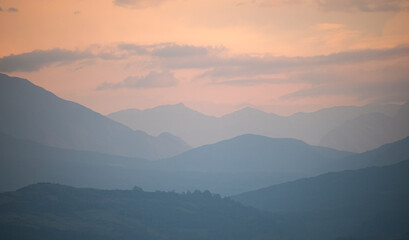 Silhouette of mountain range landscape at cloudy dawn