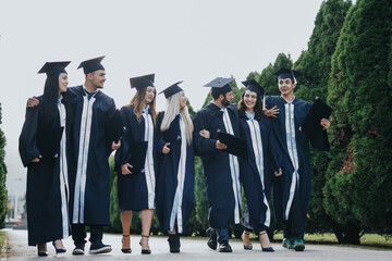 Successful Multiethnic University Students Celebrating Graduation in Park
