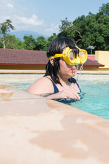 Girl with googles in swimming pool in hot sunny day