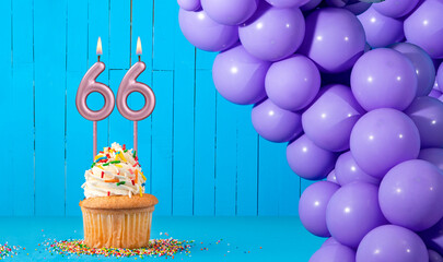 Birthday card with number 66 candle, cupcake and balloons