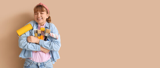 Young woman with paint rollers and brushes on beige background. Repair concept