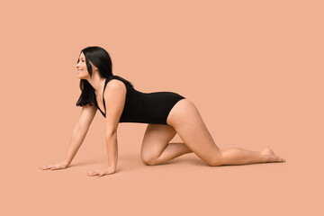 Body positive young woman on beige background