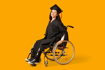 Beautiful female graduate student in wheelchair with graduation cap on yellow background