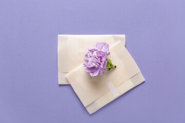 Menstrual pads with carnation flower on purple background