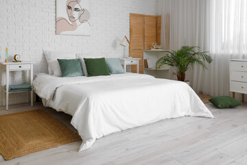 Interior of modern bedroom with soft pillows on cozy bed
