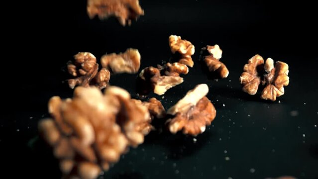 Slow motion of walnuts on black background
