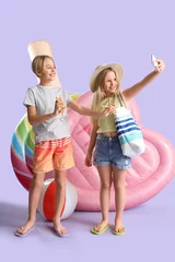 Foto op Canvas Cute little kids with inflatable mattresses and starfishes taking selfie on lilac background © Pixel-Shot