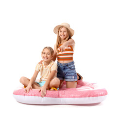 Cute little kids sitting on inflatable mattress and pointing and pointing at something on white...