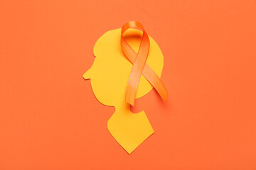 Paper human head and orange ribbon on color background. Multiple Sclerosis Awareness Month