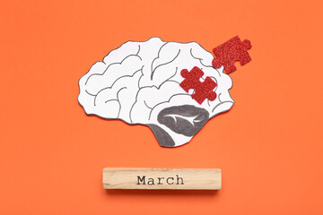 Paper brain with puzzle pieces and word MARCH on orange background. Multiple Sclerosis Awareness...