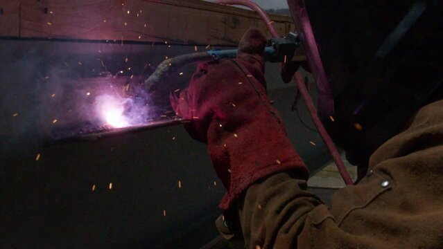 Job site welding metal beam with sparks