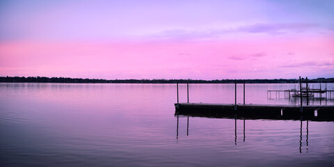 Tranquil relaxing sunset landscape over the dock at Schluter Beach in Monona Lake, Dane County,...