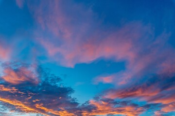 Beautiful shot of pink clouds in a clear blue sky with a scenery of sunrise