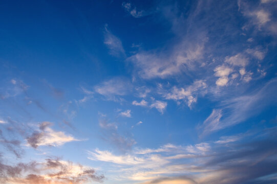 Pastel light cirrus clouds in the blue sky during dawn sunset sunrise, sky background
