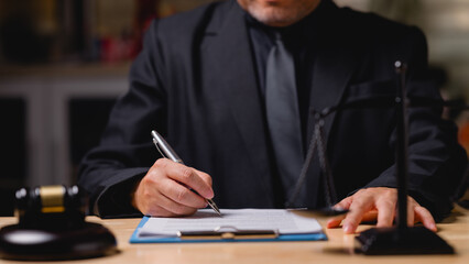 A man in a suit is writing on a piece of paper